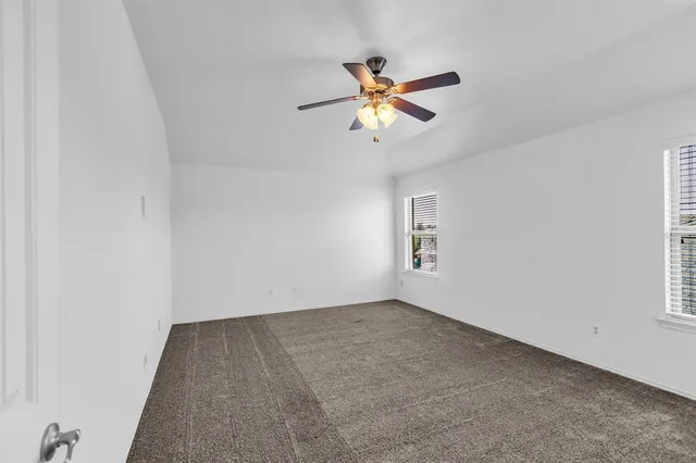 an empty room with a window and a fan