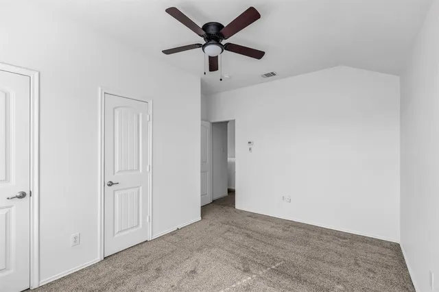 a view of a big room with windows and chandelier fan