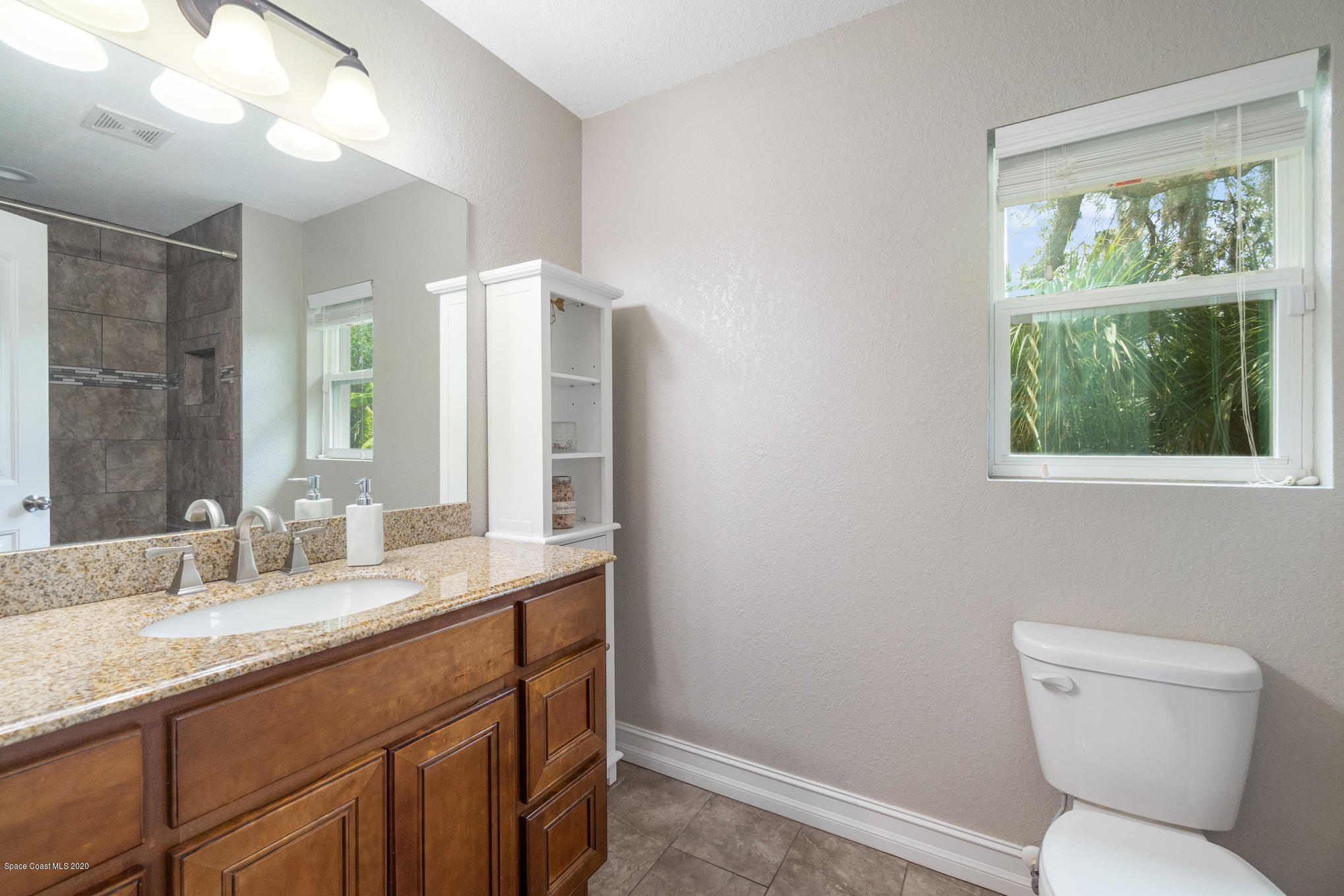 3452 Brevard Road Mims, FL 32754 - Photo 14 of 23 a bathroom with a toilet sink and mirror