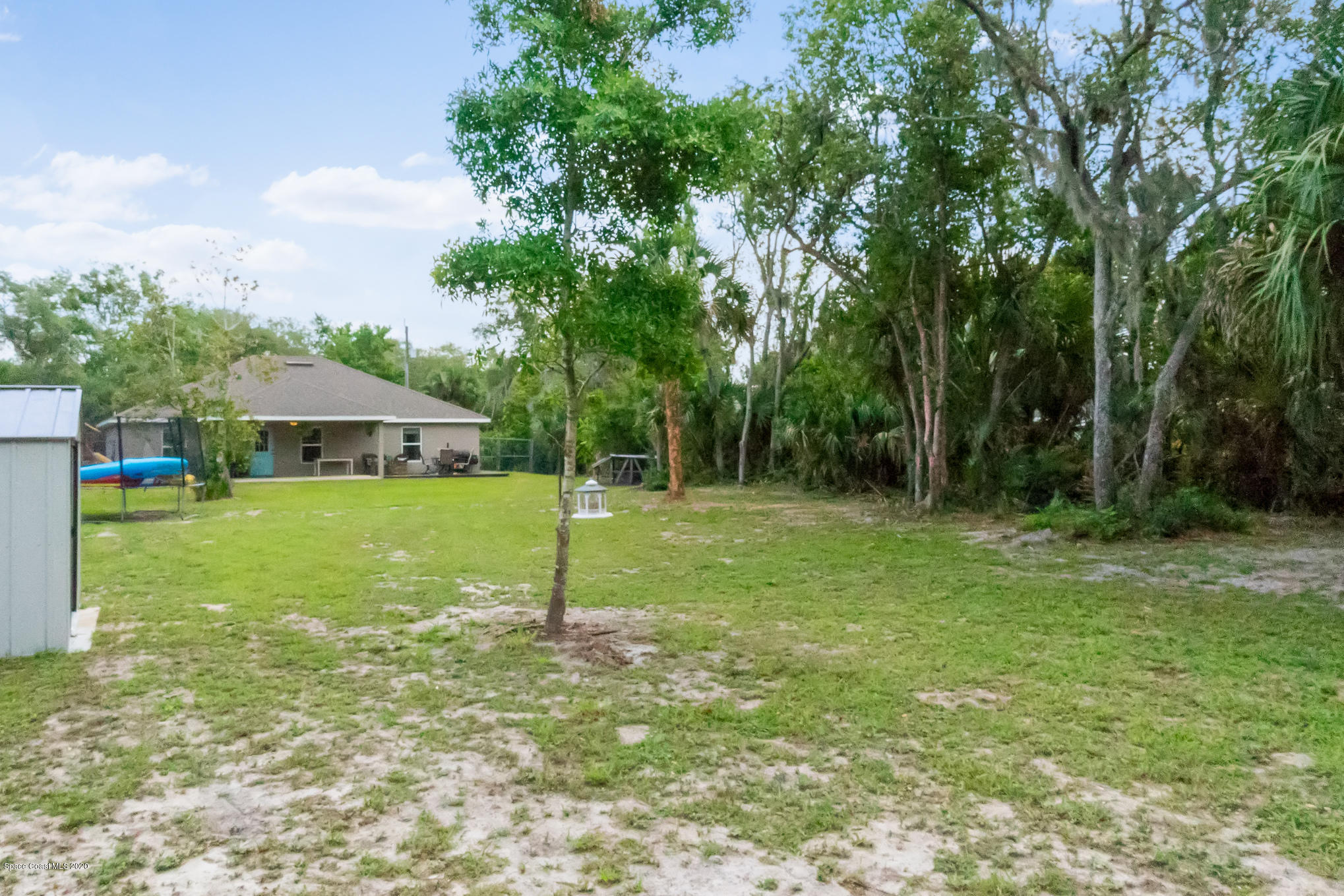 3452 Brevard Road Mims, FL 32754 - Photo 22 of 23 a view of a house with backyard and trees