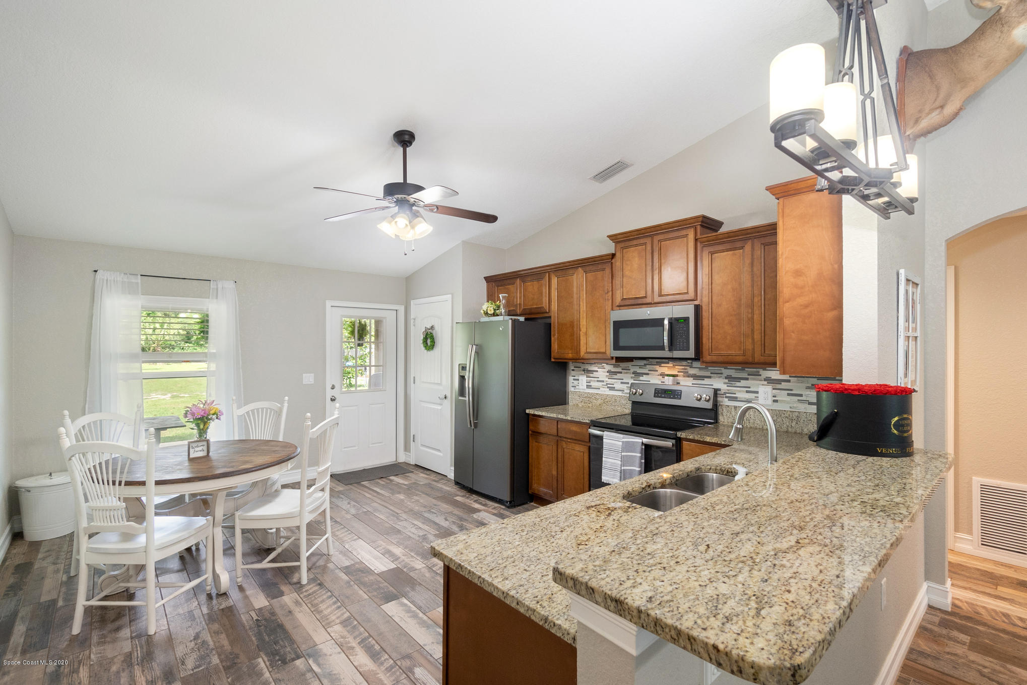 3452 Brevard Road Mims, FL 32754 - Photo 8 of 23 a kitchen with a stove a refrigerator and a dining table