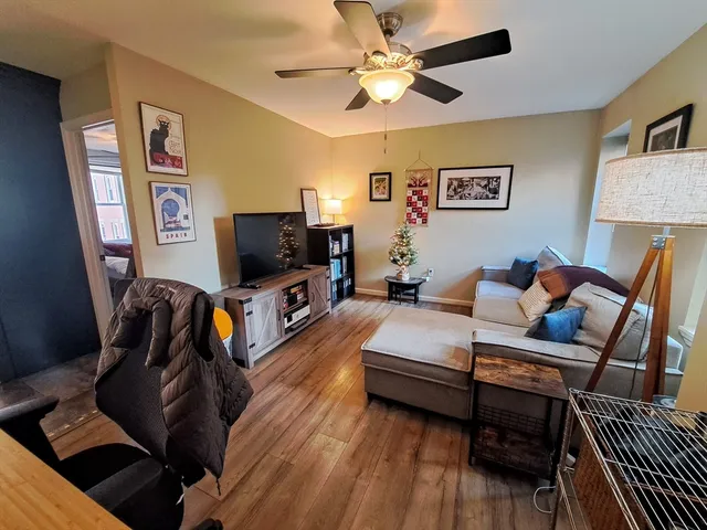 a living room with furniture a flat screen tv and a window