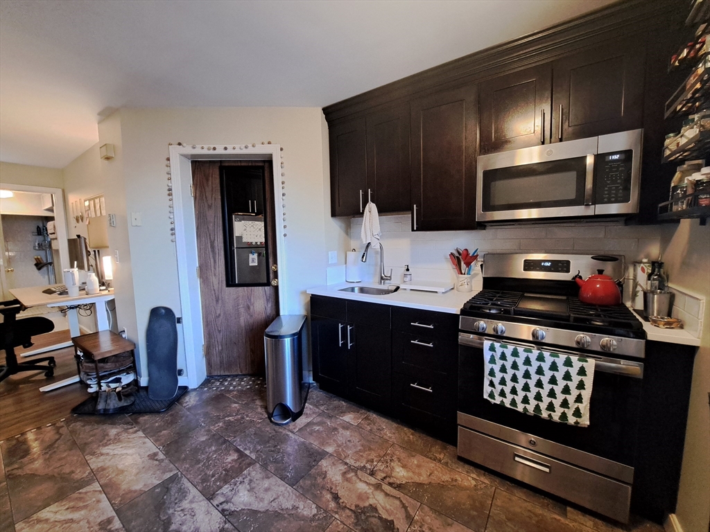 38 Charter Street, Unit 11 Boston, MA 02113 - Photo 4 of 17 a kitchen with stainless steel appliances kitchen island granite countertop a refrigerator stove and sink