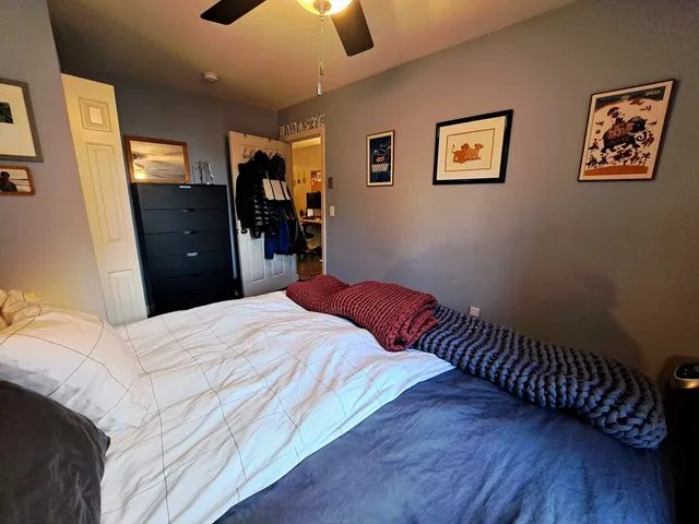 a bedroom with a bed and painting on the wall