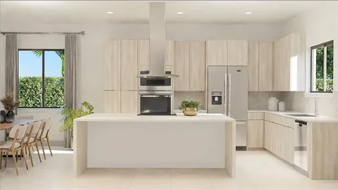 a living room with stainless steel appliances a white table chairs and a refrigerator