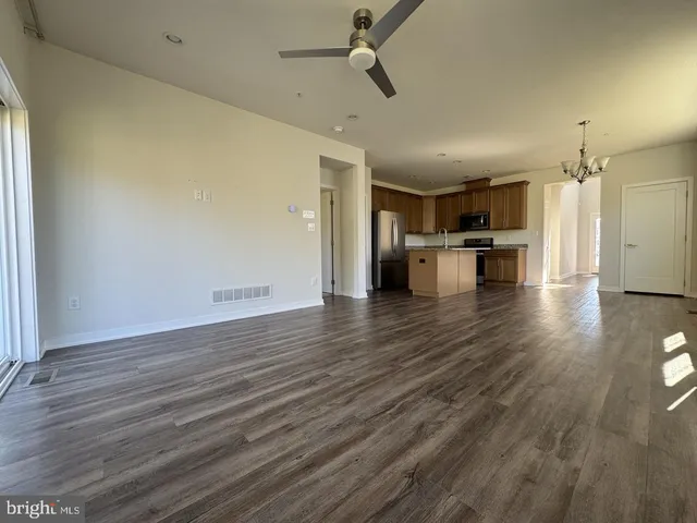 a view of a kitchen with a sink and dishwasher a oven with wooden floor