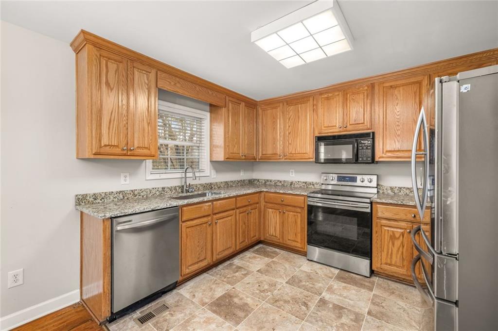 4239 Mangum Mill Road Gainesville, GA 30507 - Photo 16 of 33 a kitchen with stainless steel appliances granite countertop a stove sink microwave and refrigerator