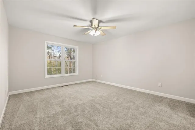 an empty room with fan and windows