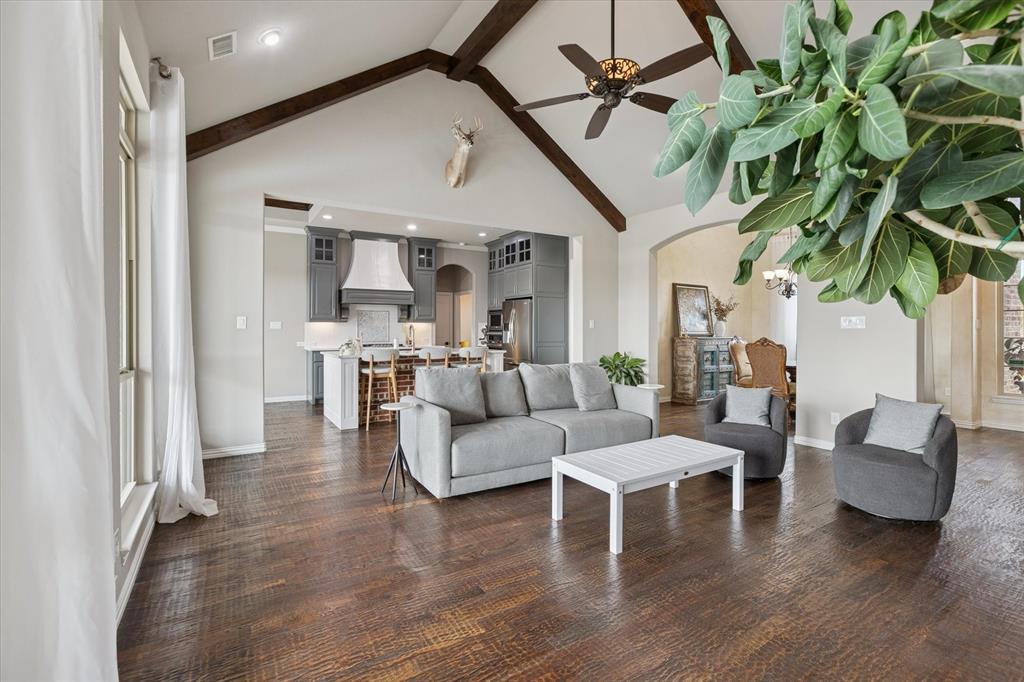 542 Pierce Road Red Oak, TX 75154 - Photo 9 of 27 Spacious living area featuring wood-finish flooring, vaulted ceilings with exposed beams, and a ceiling fan