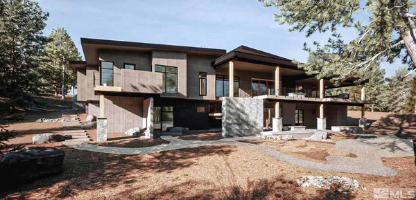 a view of a house with chairs and a tree