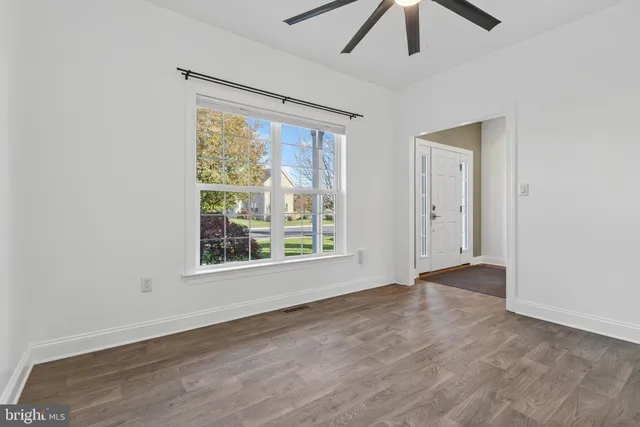 a kitchen with stainless steel appliances kitchen island granite countertop a refrigerator a stove a sink dishwasher and white cabinets with wooden floor