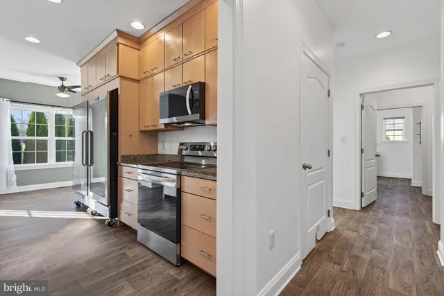 a kitchen with stainless steel appliances granite countertop a refrigerator a sink and a stove