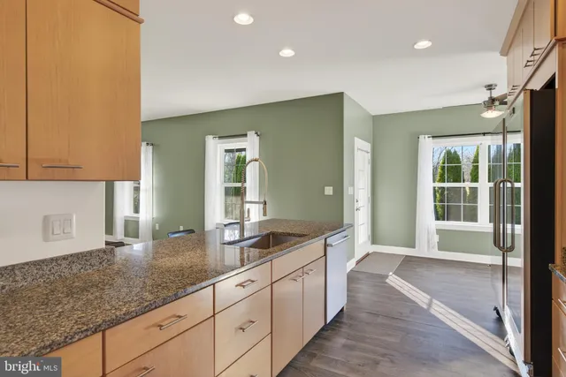 a view of a hallway with wooden floor and cabinet