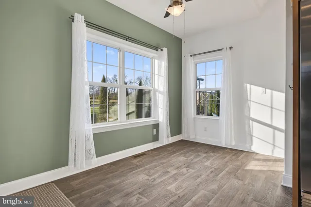 an empty room with windows and a fireplace