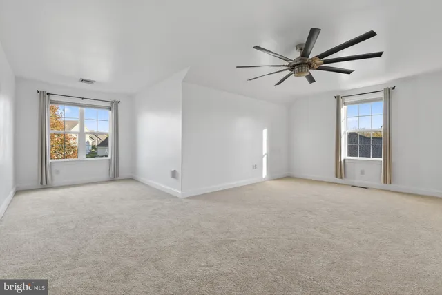 a view of empty room with wooden floor and window