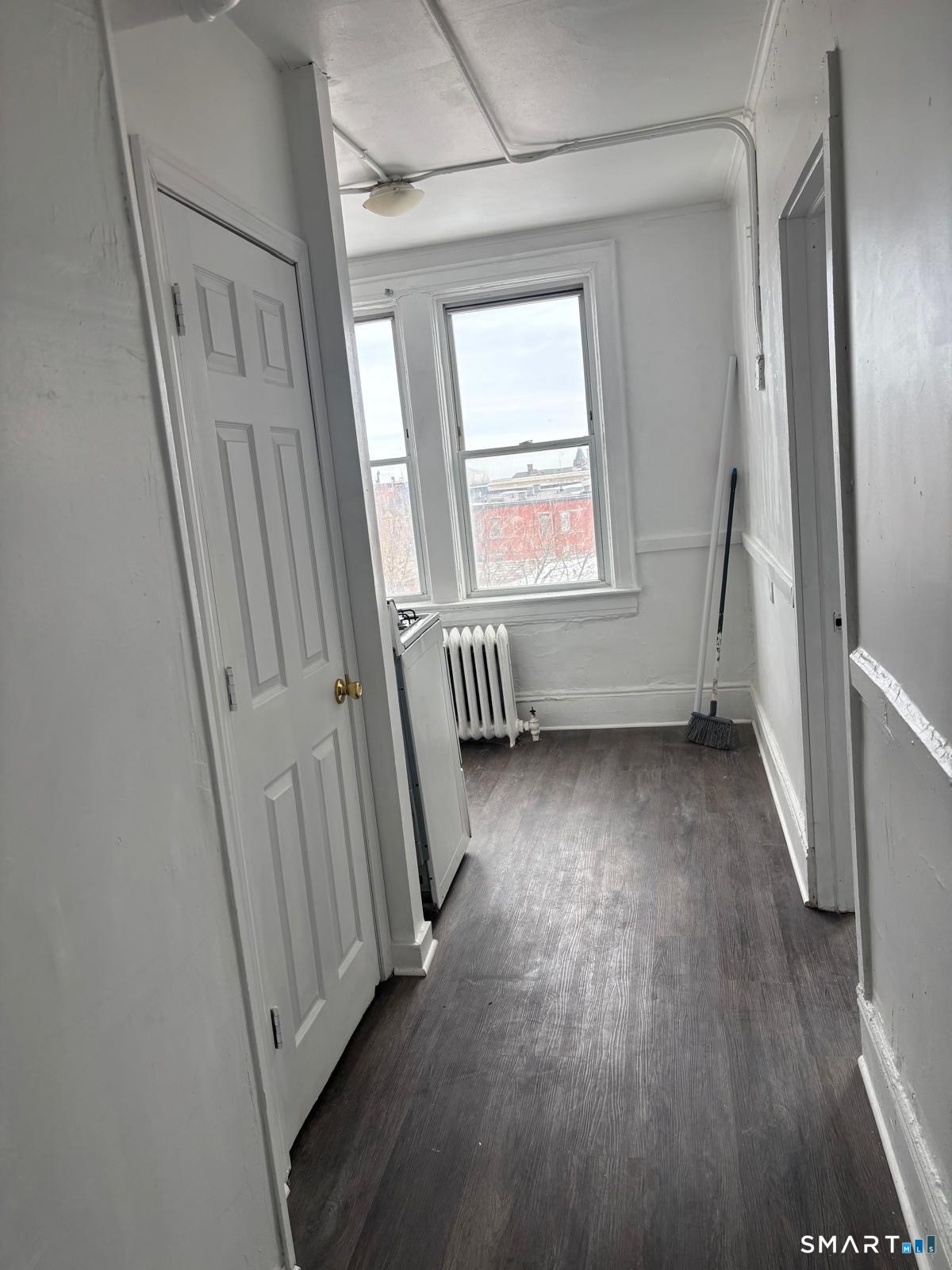 86 Pequonnock Street, Unit 3 Bridgeport, CT 06604 - Photo 3 of 4 an empty room with wooden floor and windows