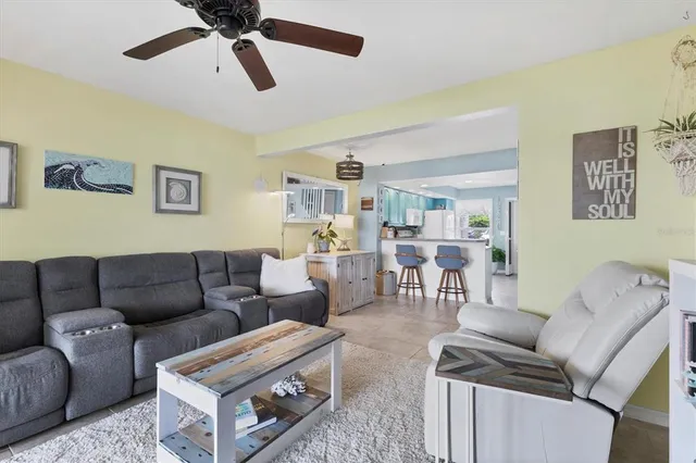 a living room with furniture and a ceiling fan