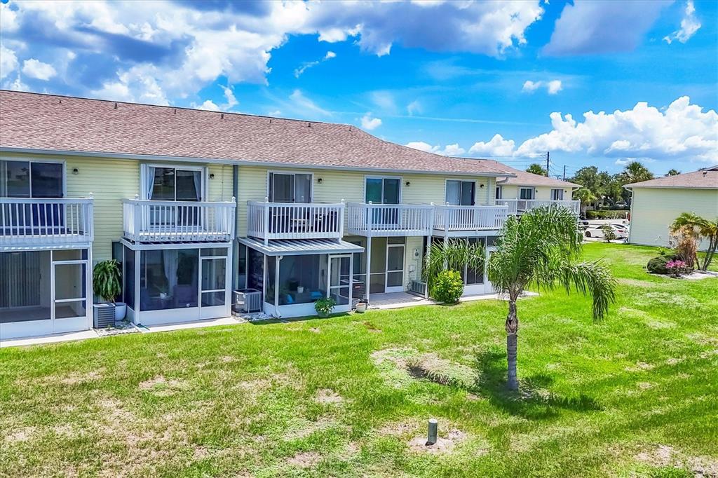 26310 Rampart Boulevard, Unit D504 Punta Gorda, FL 33983 - Photo 39 of 46 a view of a house with a big yard and potted plants