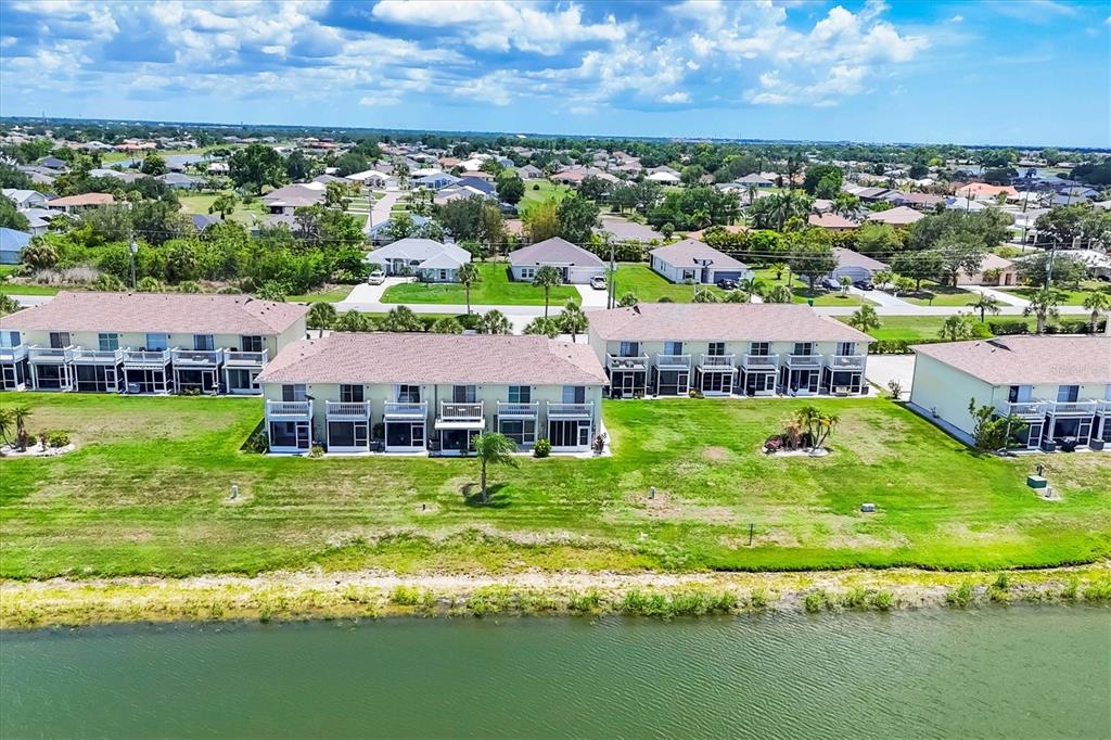 26310 Rampart Boulevard, Unit D504 Punta Gorda, FL 33983 - Photo 41 of 46 an aerial view of residential houses with yard and lake view