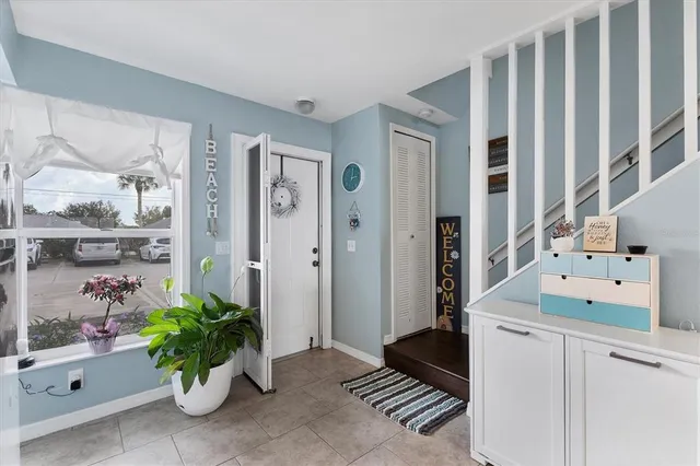 a hallway with a dining table a potted plant and a rug