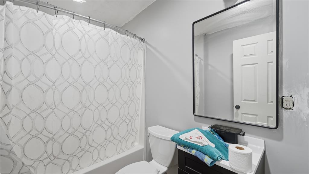 655 Northwest Nw Loop Smithville, TX 78957 - Photo 8 of 13 a bathroom with a toilet and a shower curtain