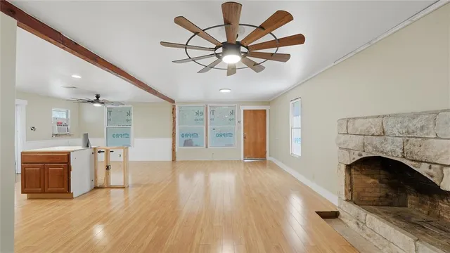 a view of empty room with wooden floor and ceiling fan