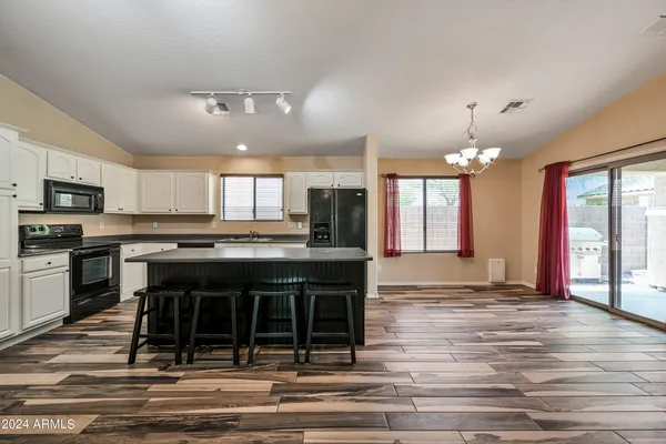 a kitchen with kitchen island granite countertop a stove and cabinets