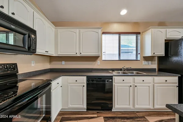 a kitchen with granite countertop a stove sink and cabinets