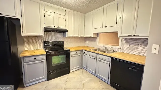 a kitchen with granite countertop white cabinets and stainless steel appliances