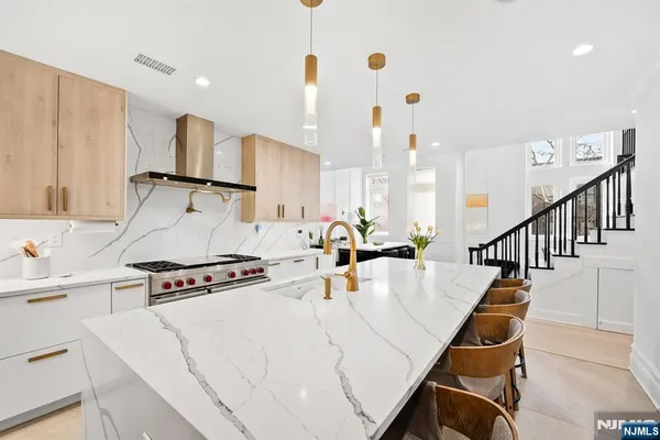 a kitchen with stainless steel appliances kitchen island granite countertop a refrigerator and a stove top oven