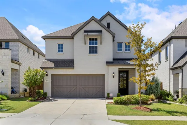 a front view of a house with a yard and potted plants