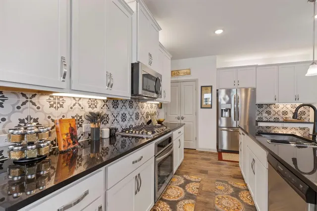 a kitchen with stainless steel appliances granite countertop a stove and a refrigerator