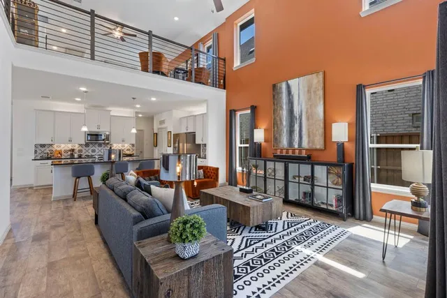 a living room with furniture kitchen view and a large window