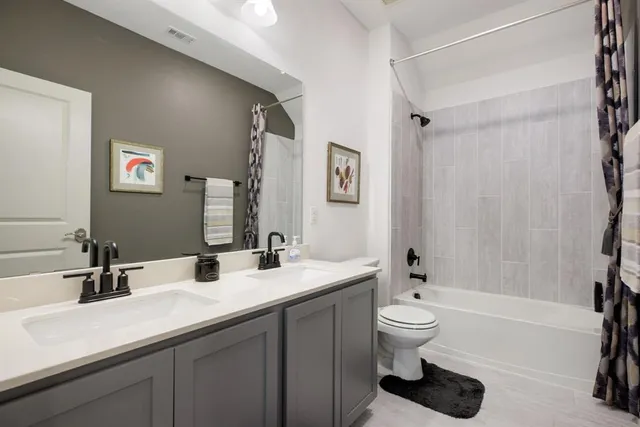 a bathroom with a double vanity sink toilet and shower