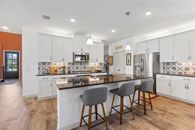 a kitchen with stainless steel appliances a sink stove and cabinets