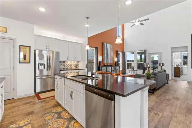 a kitchen with stainless steel appliances granite countertop a refrigerator a stove and a sink