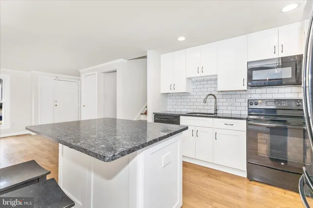 a kitchen with granite countertop a stove and a sink