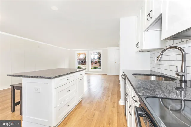a large kitchen with stainless steel appliances granite countertop a refrigerator and a sink