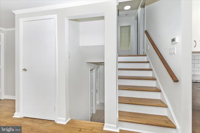 an empty room with wooden floor and wall painting