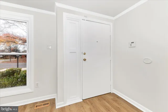 a view of a small space with wooden floor and a window