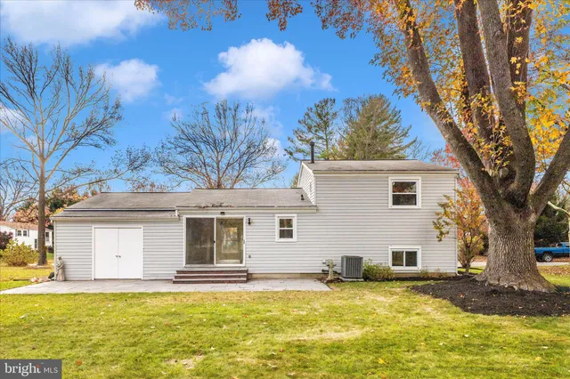 a view of a white house with a large tree