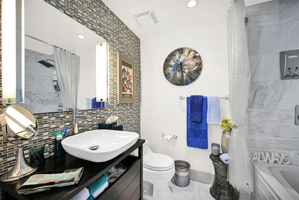 a bathroom with a tub a toilet and a shower
