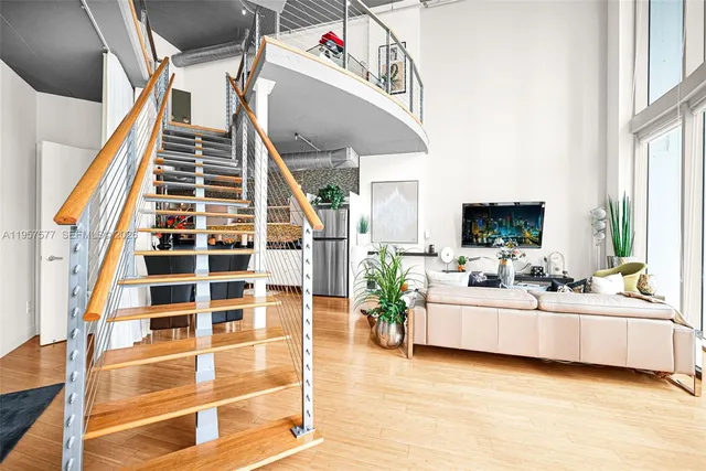 a living room with stainless steel appliances kitchen island granite countertop furniture a rug and a window