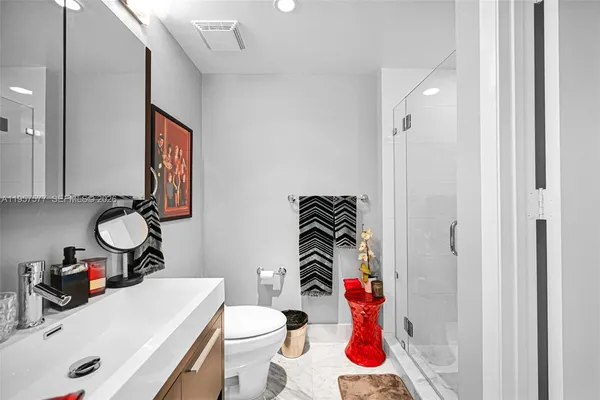 a bathroom with a sink vanity mirror and toilet