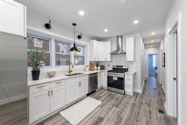 a kitchen with white cabinets and appliances