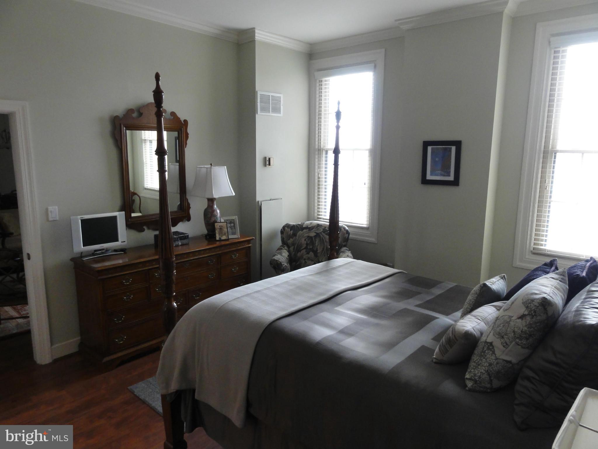 1 East Chase Street, Unit 814 Baltimore, MD 21202 - Photo 24 of 27 a bedroom with a bed and wooden floor