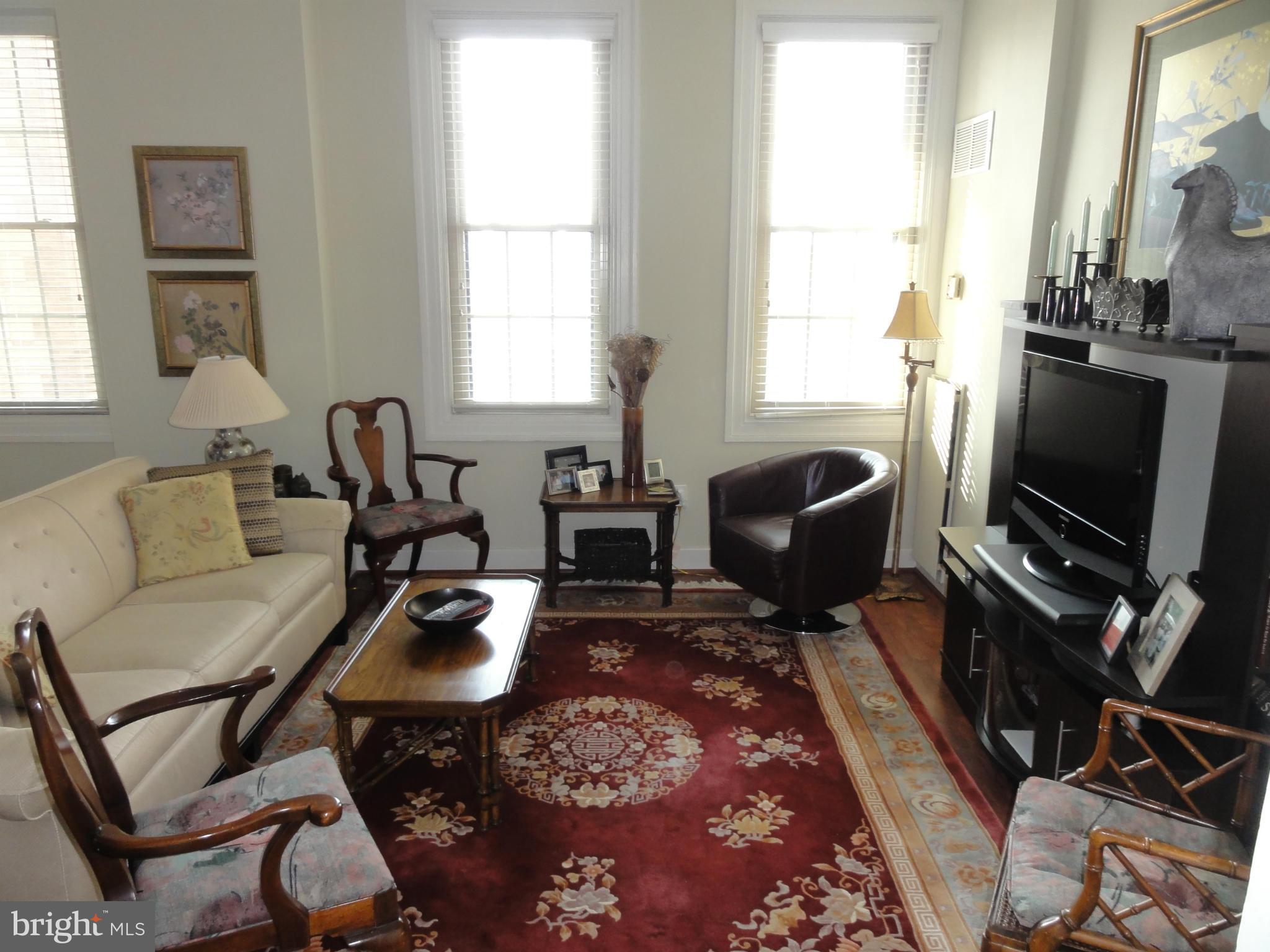 1 East Chase Street, Unit 814 Baltimore, MD 21202 - Photo 5 of 27 a living room with furniture a flat screen tv and a window