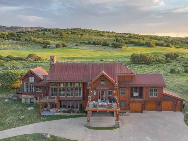 a front view of a house with a yard and lake view
