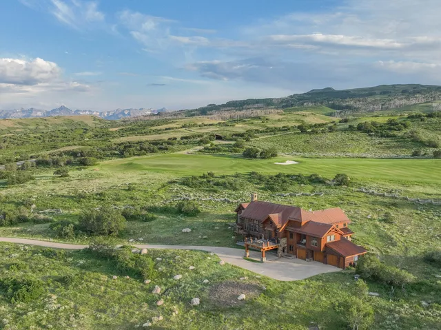a view of a lake with a table and chairs in the patio