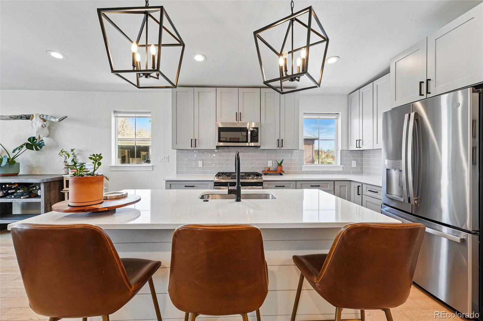 949 Raleigh Street, Unit 2 Denver, CO 80204 - Photo 12 of 42 a kitchen with stainless steel appliances granite countertop a refrigerator a sink dishwasher a dining table and chairs with wooden floor